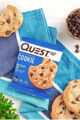 Quest Nutrition Protein Cookie chocolate chip on a blue towel, showcasing 15g protein and 4g net carbs.