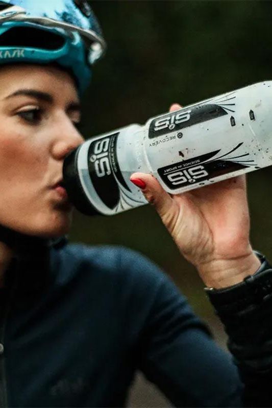 Athlete using Science in Sport water bottle for hydration during cycling.