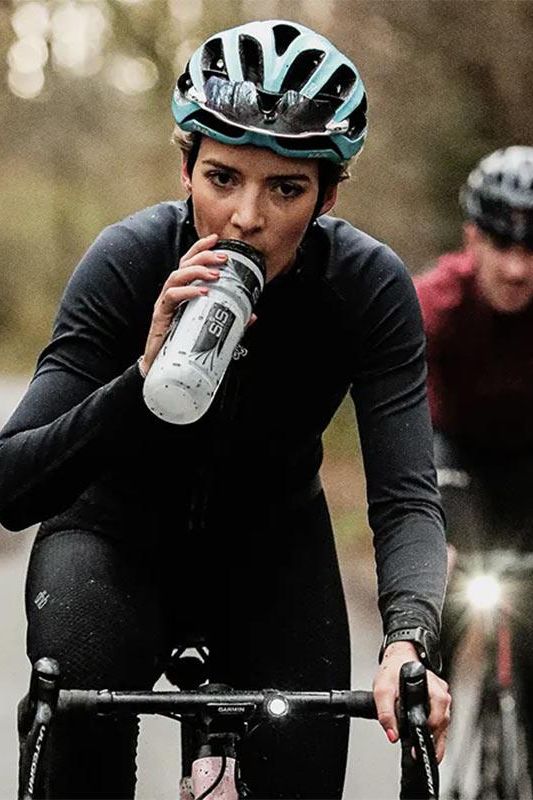 Cyclist drinking Science in Sport GO Electrolyte Powder for hydration during training.