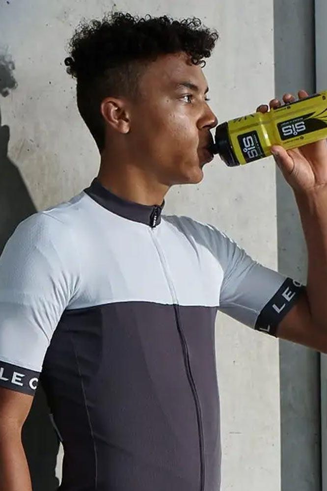 Athlete drinking Science in Sport Turbo+ Powder from a sports bottle, promoting hydration during training.