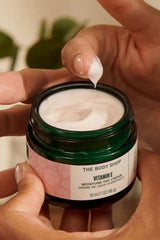 The Body Shop Vitamin E Moisture Day Cream in a green jar, showcasing creamy texture for dry skin hydration.