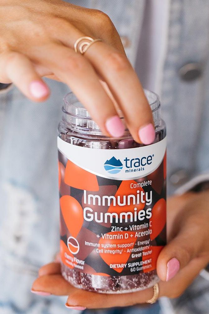 Trace Minerals Immunity Gummies bottle with a hand holding it, showcasing zinc and vitamin C benefits.