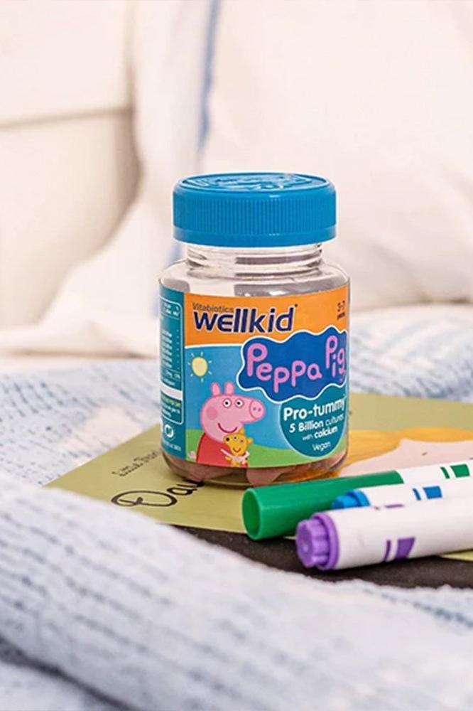 Wellkid Peppa Pig Pro-tummy gummies bottle on a table with markers, designed for kids aged 3-7, promoting digestive health.