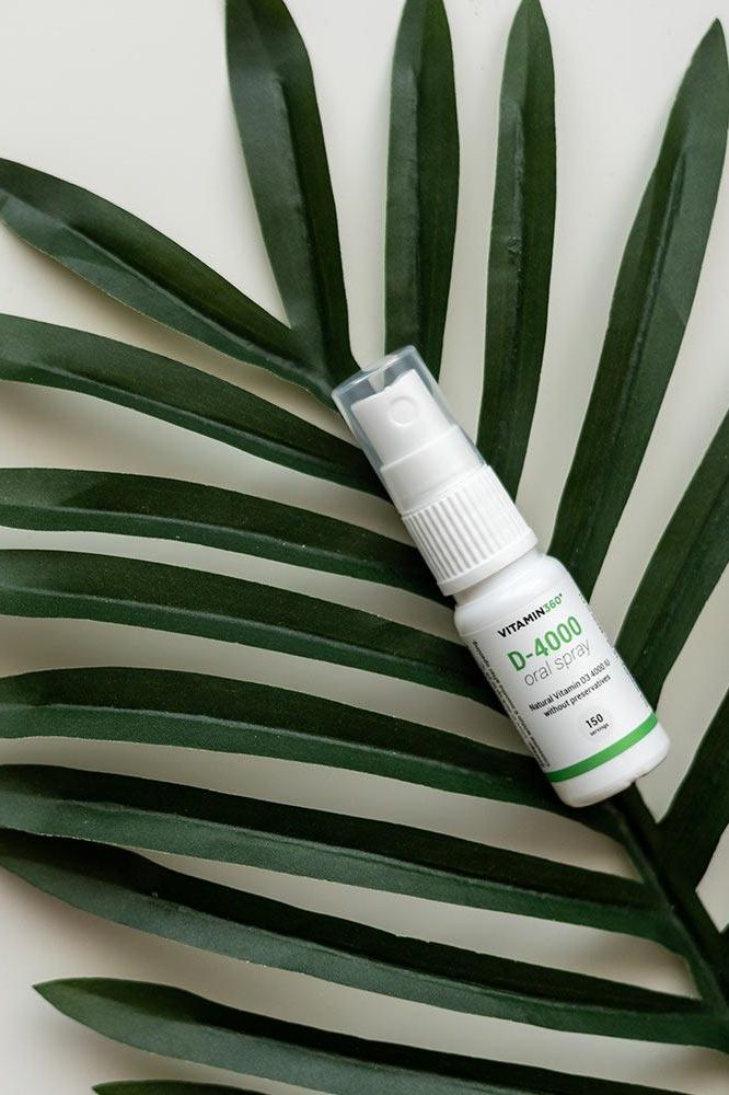 Vitamin360 D-4000 oral spray on palm leaves, providing a refreshing way to boost vitamin D intake.