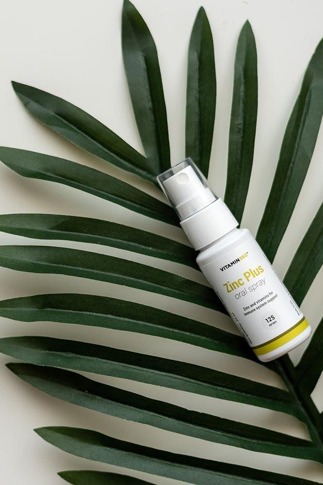 Vitamin360 Zinc Plus Oral Spray on green palm leaves, refreshing pineapple flavor, convenient zinc supplement, 25 ml.